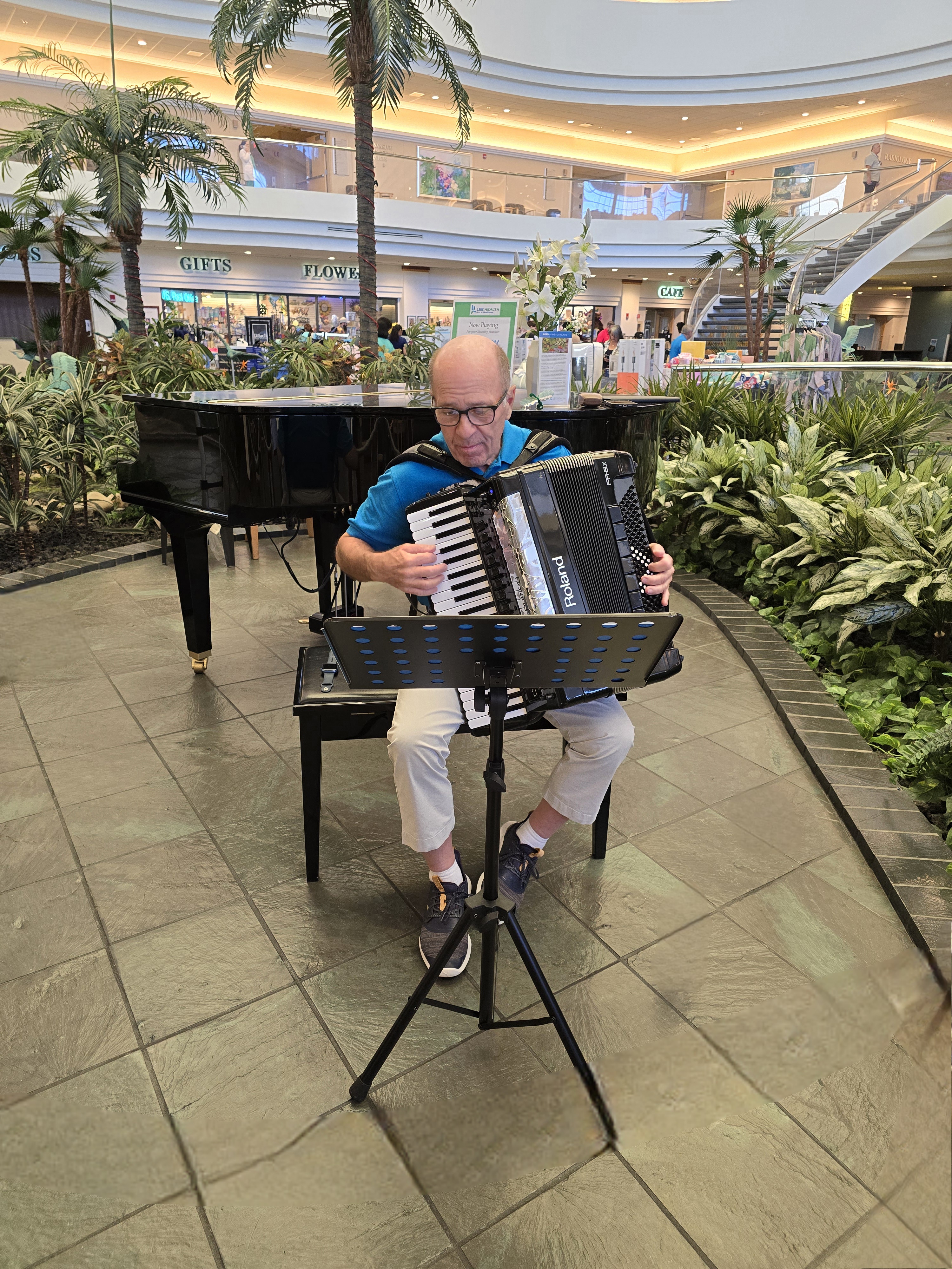 Man sitting on a chair and playing the accordian