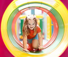 Child crawling through colorful tube