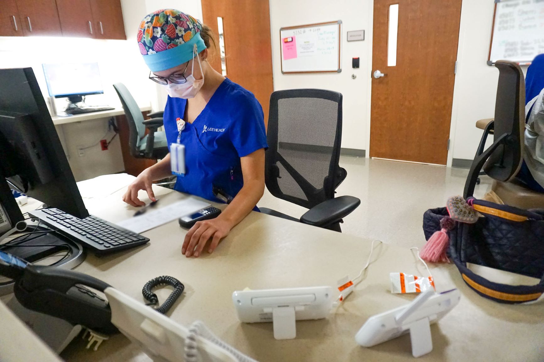 Sydnee Russo, RN, takes notes for some of her patients and continues to check the monitors of two patients who need extra care.