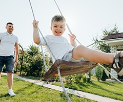 Father pushing son on swings