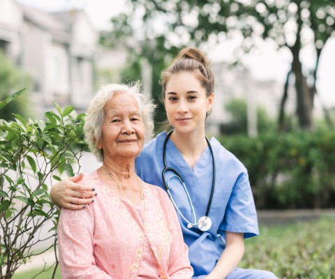 Nurse sitting with elderly patient