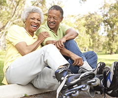 Senior couple laughing on rollerblades