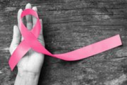 a hand holding a pink cancer ribbon 