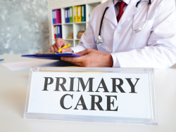 Physician behind a primary care sign 