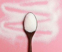 Spoon of sugar, pink background