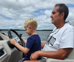 Don Grondin and grandson driving a boat