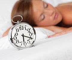 Woman sleeping with alarm clock