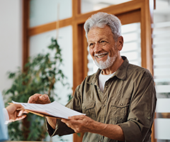 Man getting paper from healthcare office receptionist