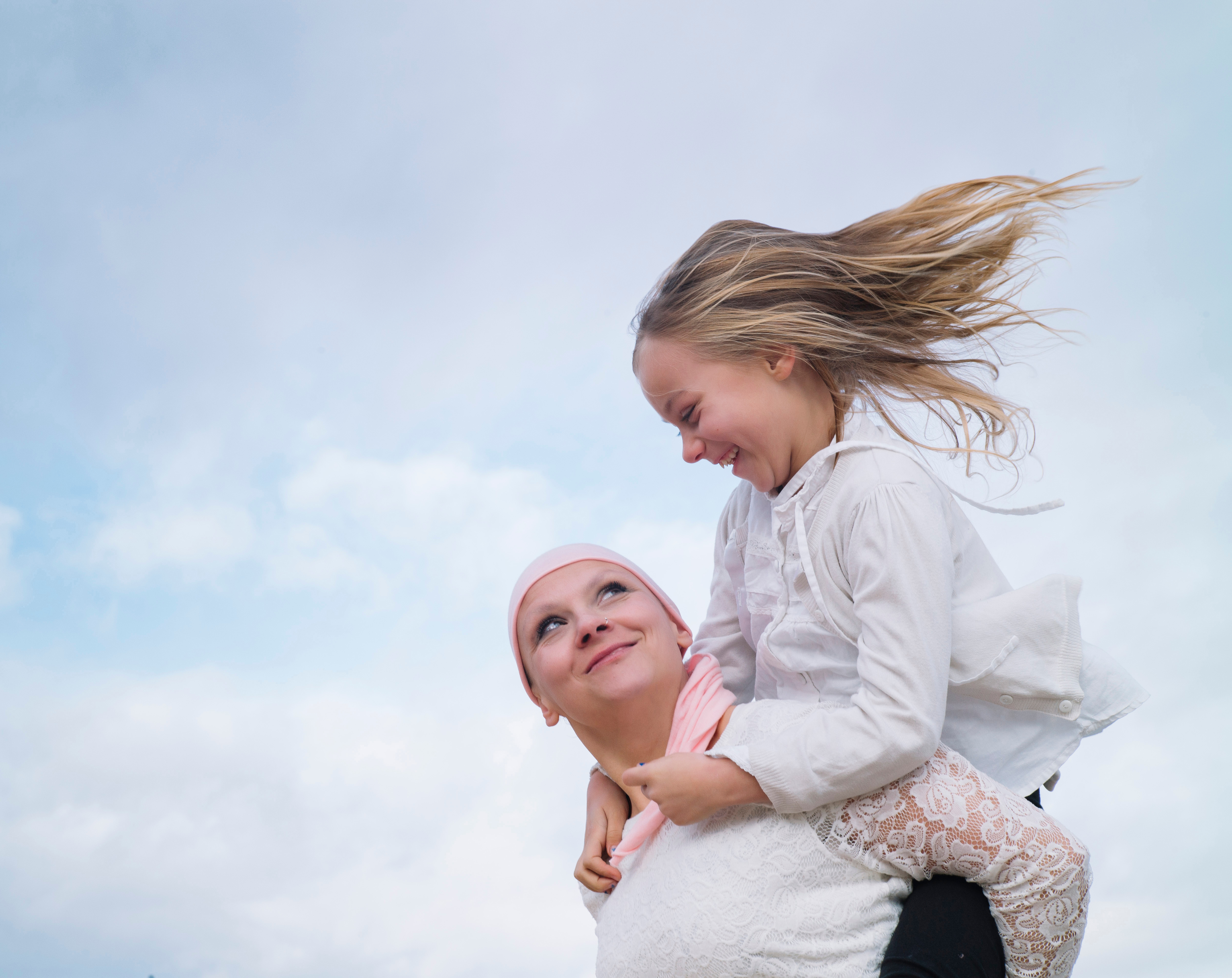 cancer survivor holding kid on their shoulders