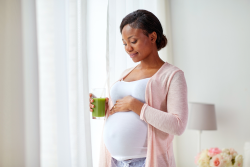 Black Pregnant Female looking at her baby bump 