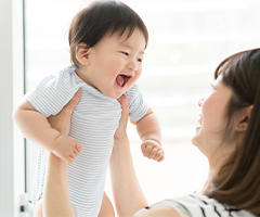 Mother holding smiling infant