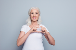 Women holding her hands in the shape of a heart. 