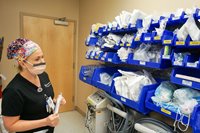 A nurse looking at a wall full of supplies 
