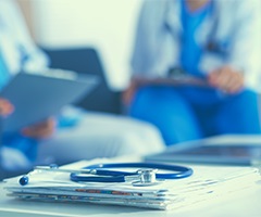 Stethoscope and nurse in background