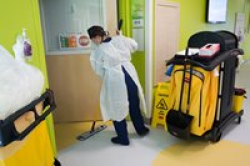 Nurse in full PPE cleaning the floors