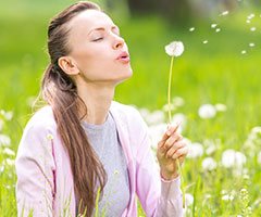 Woman blowing dandelion