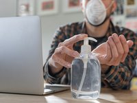 A Man working from putting on hand sanitizer 