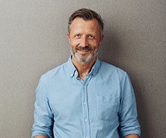 Man smiling against gray wall