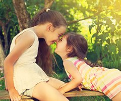 Two little girls touching noses