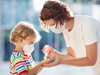 Mother Giving Son Hand Sanitizer 