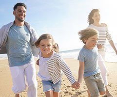 Family running on the beach