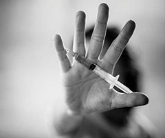 Hand holding needle, drug addiction