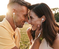 Man and woman sharing headphones