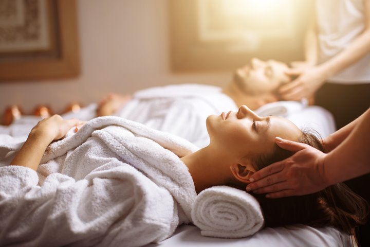 Person on massage table with head being massage